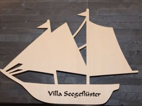 Unserer Holzschiff und Logo der Villa Seegeflüster